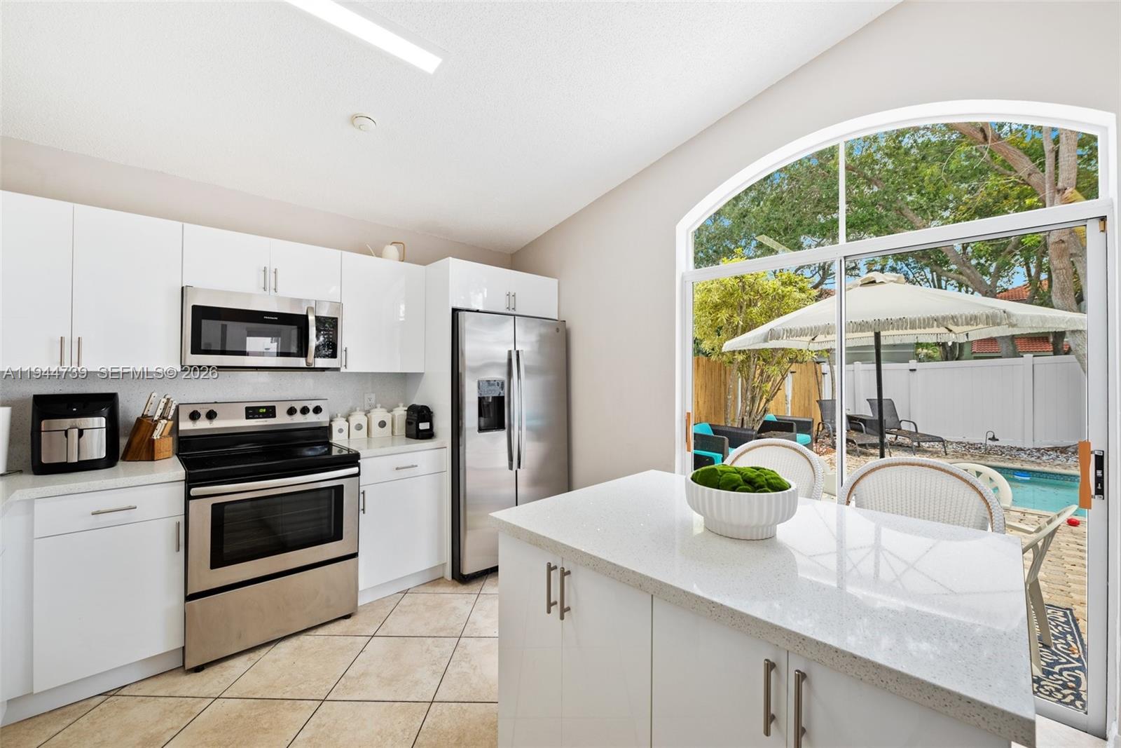 955 Azure Lane Weston, FL 33326 - Photo 13 of 34 a kitchen with stainless steel appliances a microwave a sink a stove a microwave and cabinets