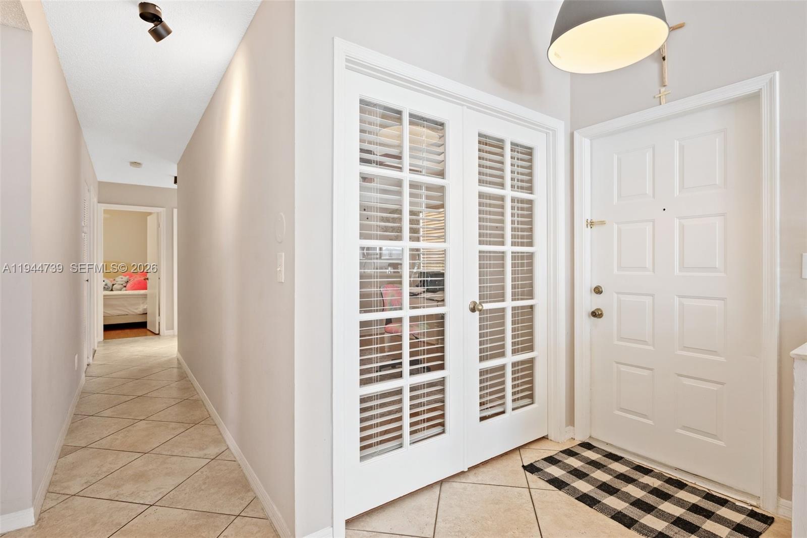 955 Azure Lane Weston, FL 33326 - Photo 6 of 34 a view of a hallway with windows and chandelier fan