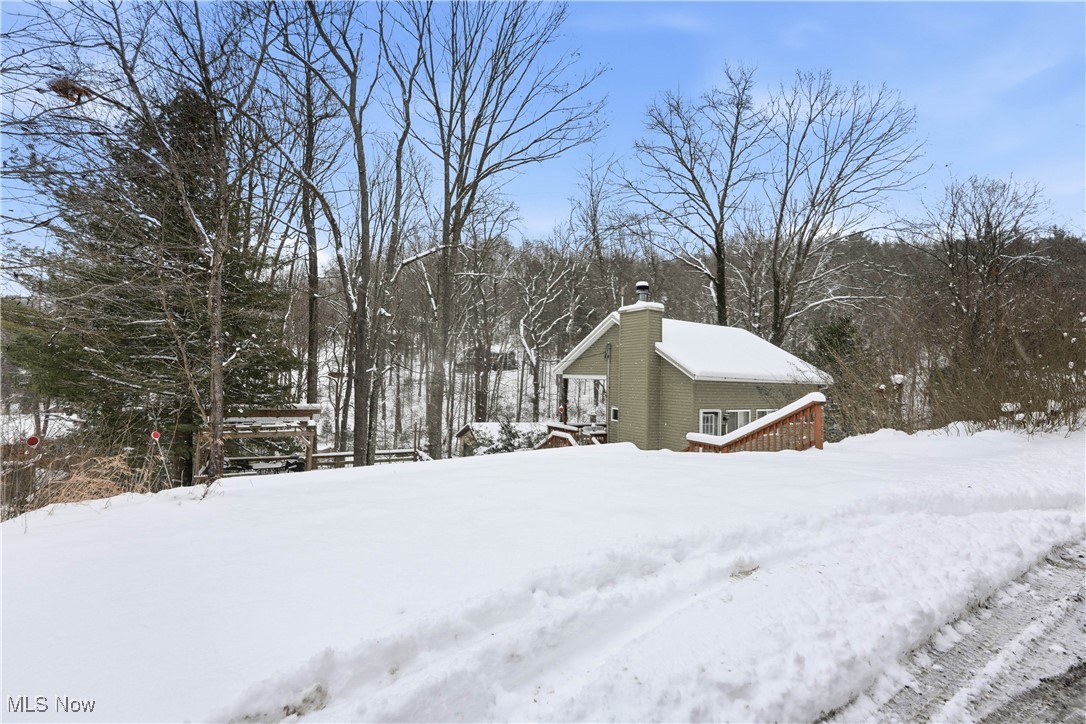 4254 Doral Road Southwest Carrollton, OH 44615 - Photo 40 of 46 Yard layered in snow with a wooden deck and view of scattered trees