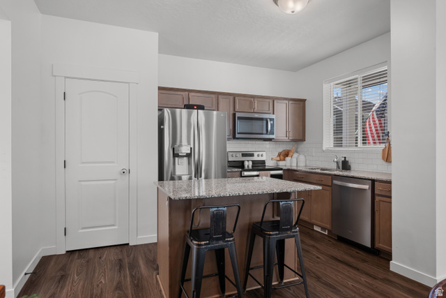 1708 North 1280th Street East Payson, UT 84651 - Photo 2 of 15 Kitchen featuring a central island with countertop seating, wood-finish flooring, and white subway tile backsplash