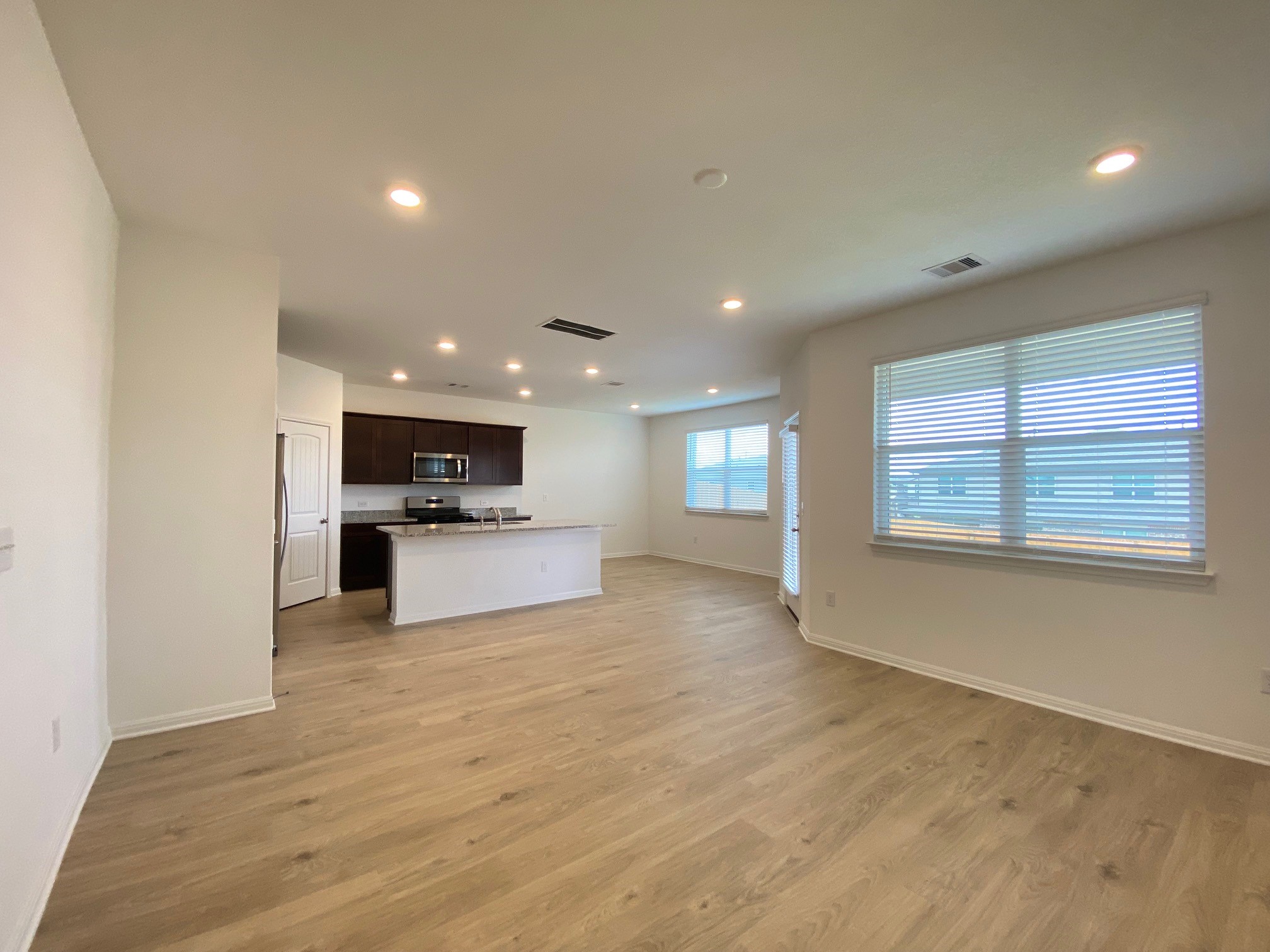 205 Saide Street Georgetown, TX 78626 - Photo 13 of 31 a view of kitchen with kitchen island a sink wooden floor and a refrigerator