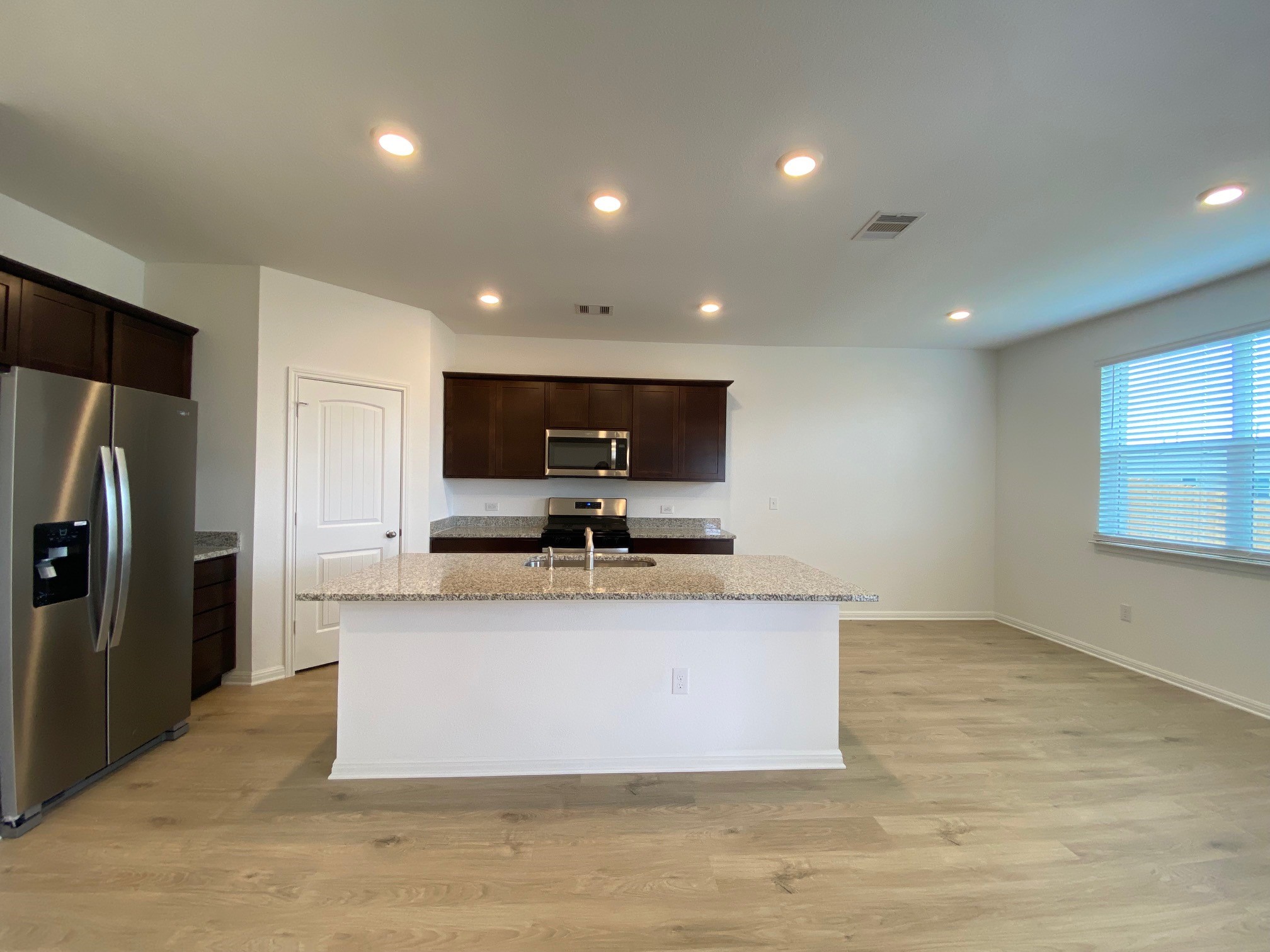 205 Saide Street Georgetown, TX 78626 - Photo 15 of 31 a view of a kitchen with stainless steel appliances granite countertop a stove a refrigerator a sink and a microwave