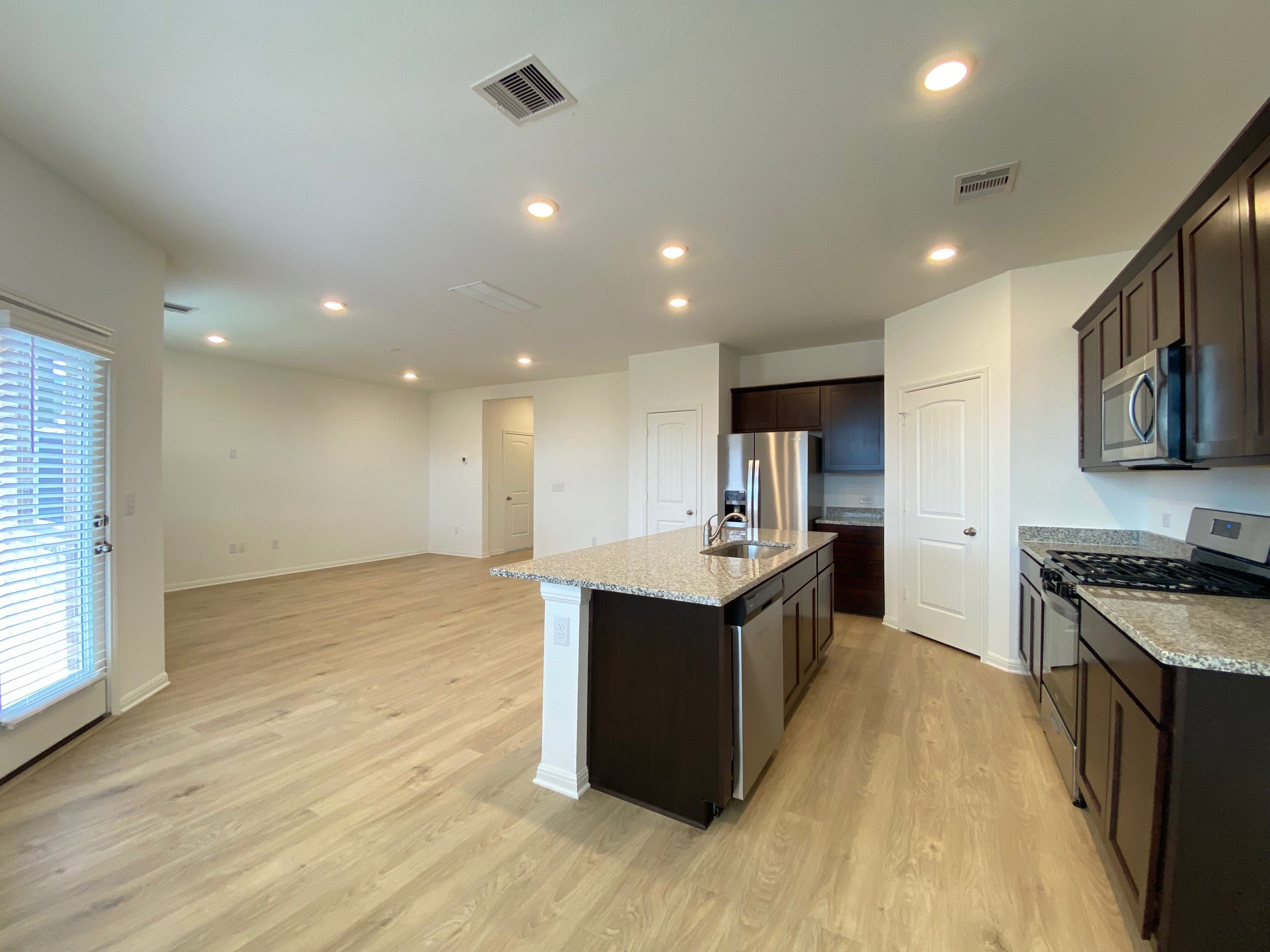 205 Saide Street Georgetown, TX 78626 - Photo 19 of 31 a large kitchen with stainless steel appliances granite countertop a large counter top and wooden floors