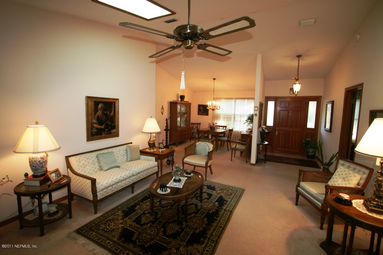 514 Gentian Road St. Augustine, FL 32086 - Photo 6 of 22 a living room with furniture a chandelier and a flat screen tv