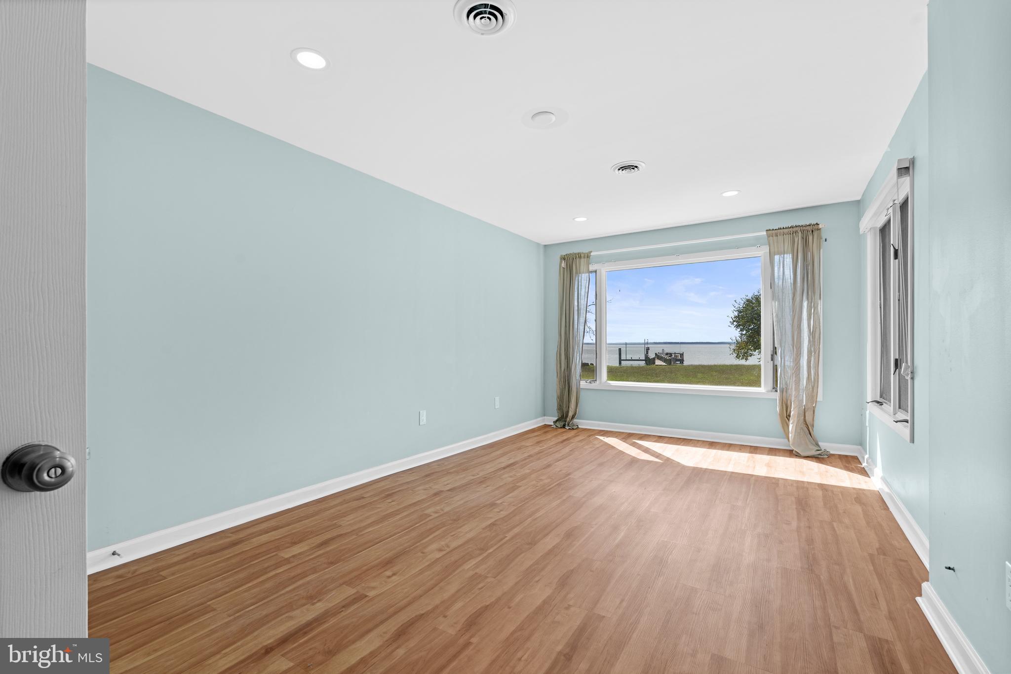 17203 Piney Point Road Piney Point, MD 20674 - Photo 23 of 43 a view of an empty room with wooden floor and a window