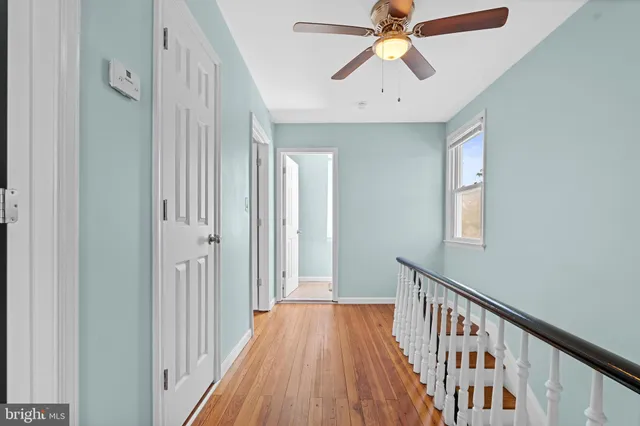 a view of a hallway with a chandelier fan