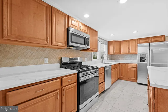 a kitchen with stainless steel appliances granite countertop a refrigerator sink stove microwave and cabinets