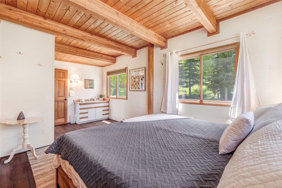 60455 Floyd Creek Road Clark, CO 80428 - Photo 21 of 50 a spacious bedroom with a bed next to a large window with the outer view