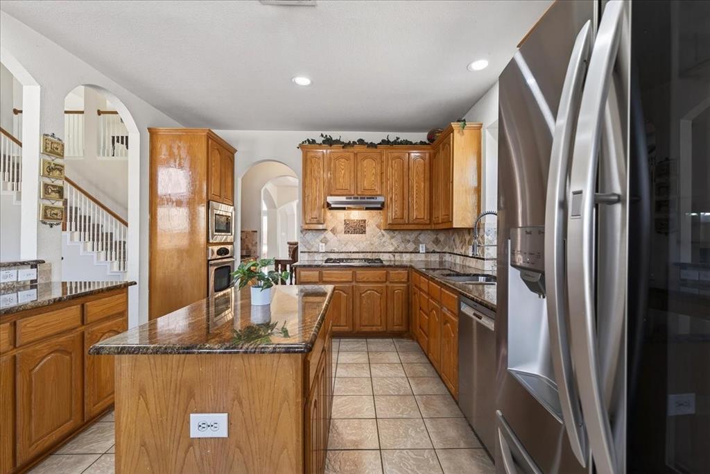 7308 Hawk Lane Sachse, TX 75048 - Photo 12 of 37 a kitchen with stainless steel appliances granite countertop a refrigerator a stove and a sink