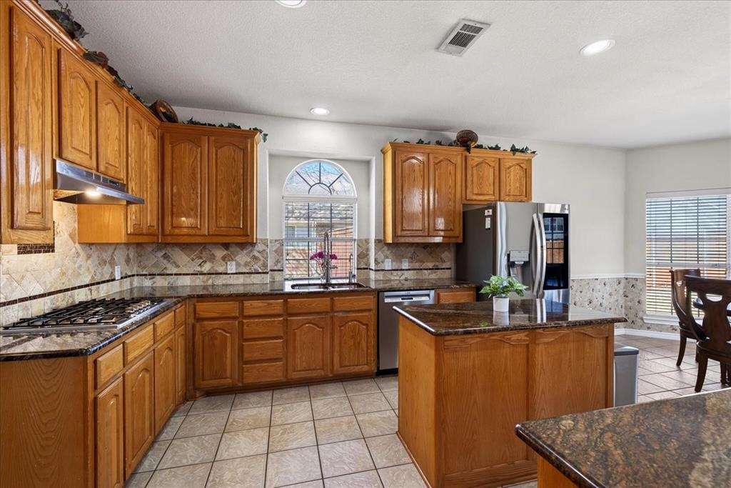 7308 Hawk Lane Sachse, TX 75048 - Photo 13 of 37 a kitchen with stainless steel appliances granite countertop a sink stove and cabinets