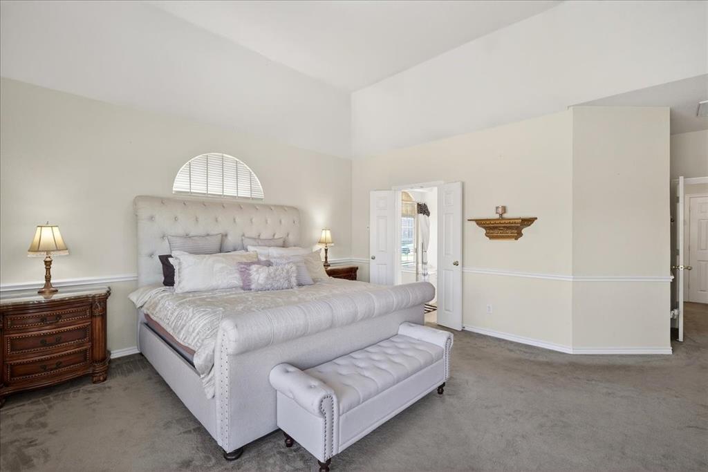 7308 Hawk Lane Sachse, TX 75048 - Photo 17 of 37 a bedroom with a bed and a chandelier