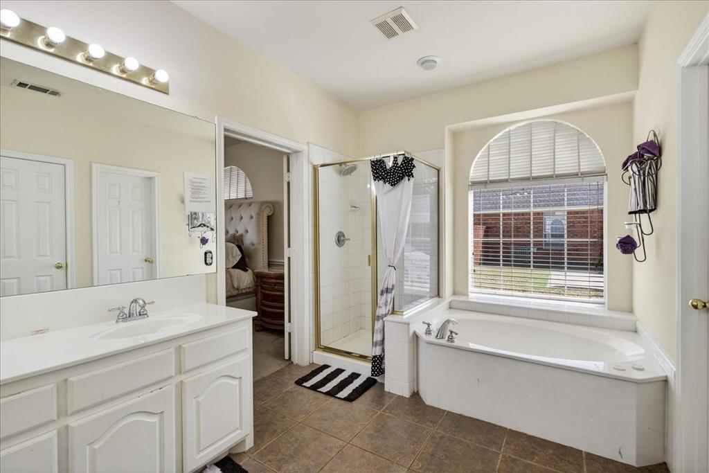 7308 Hawk Lane Sachse, TX 75048 - Photo 19 of 37 a bathroom with a tub sink shower and mirror