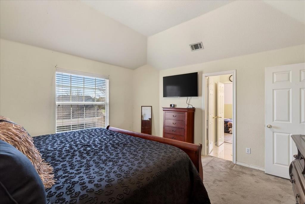 7308 Hawk Lane Sachse, TX 75048 - Photo 25 of 37 a bedroom with a bed and a flat screen tv