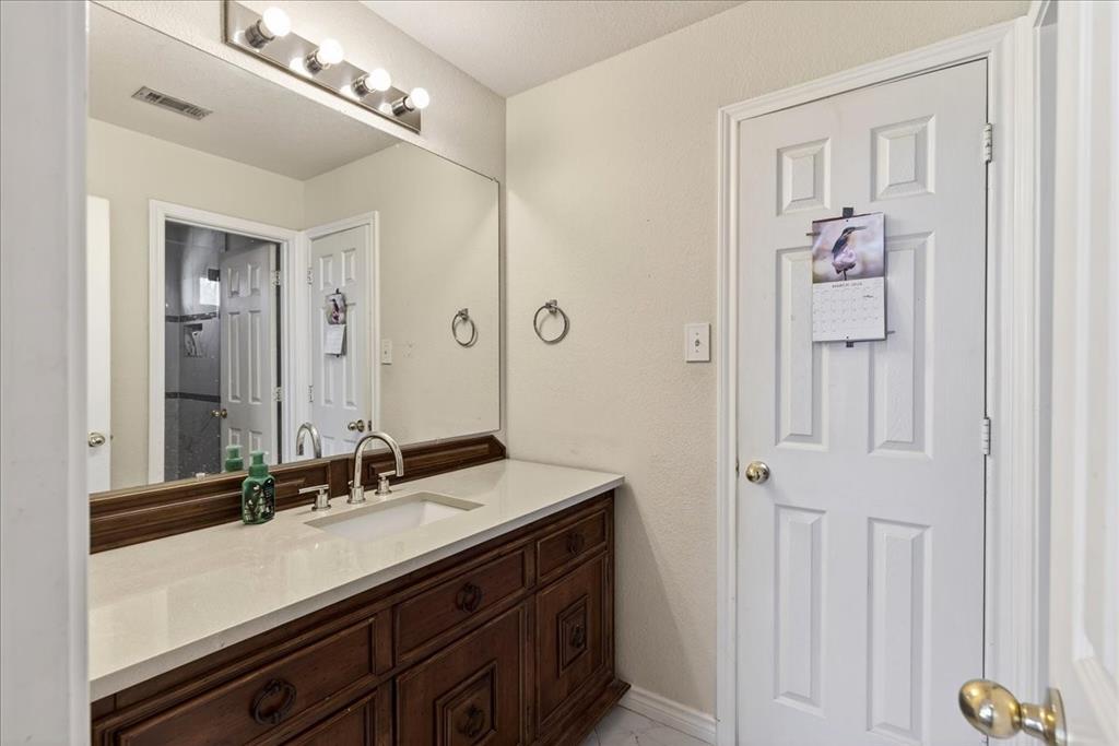 7308 Hawk Lane Sachse, TX 75048 - Photo 27 of 37 a bathroom with a sink vanity and a mirror