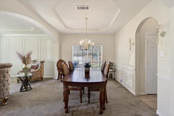 a dining room with furniture a chandelier and window