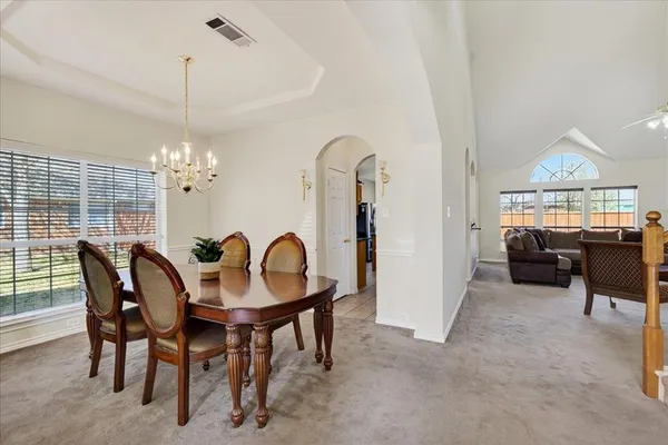 a living room with furniture a chandelier and a flat screen tv