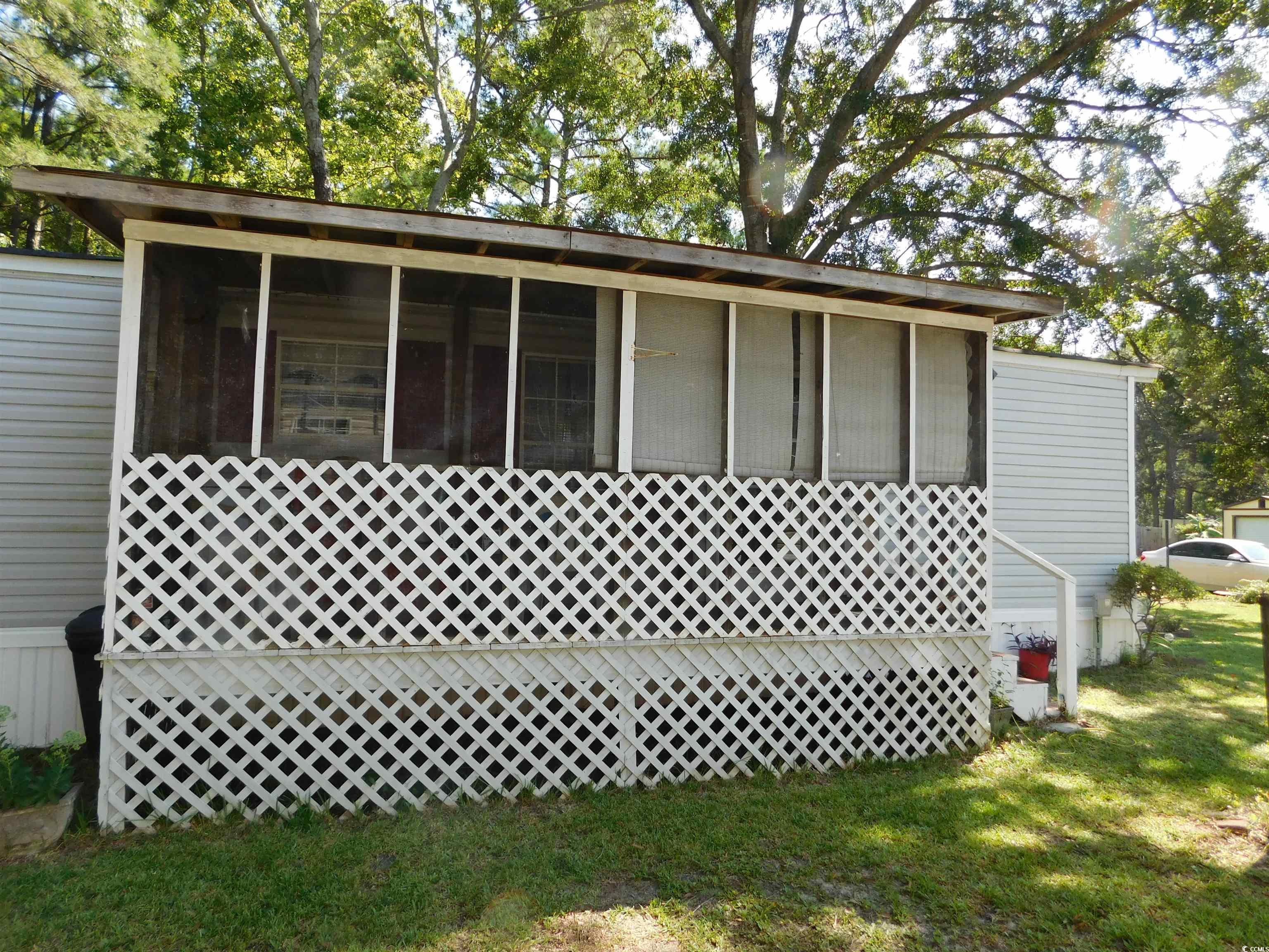 112 Offshore Drive Murrells Inlet, SC 29576 - Photo 2 of 14 View of home's exterior with a sunroom and a lawn