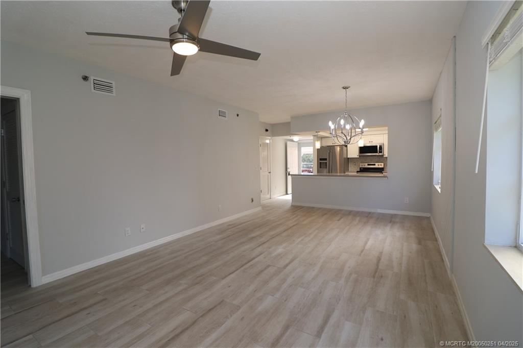 2950 Southeast Ocean Boulevard, Unit 101 Stuart, FL 34996 - Photo 11 of 35 wooden floor in an empty room with a window