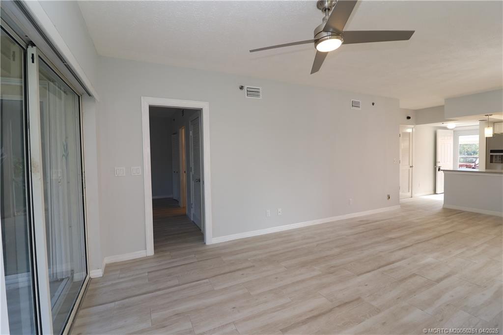 2950 Southeast Ocean Boulevard, Unit 101 Stuart, FL 34996 - Photo 12 of 35 wooden floor in an empty room with a window