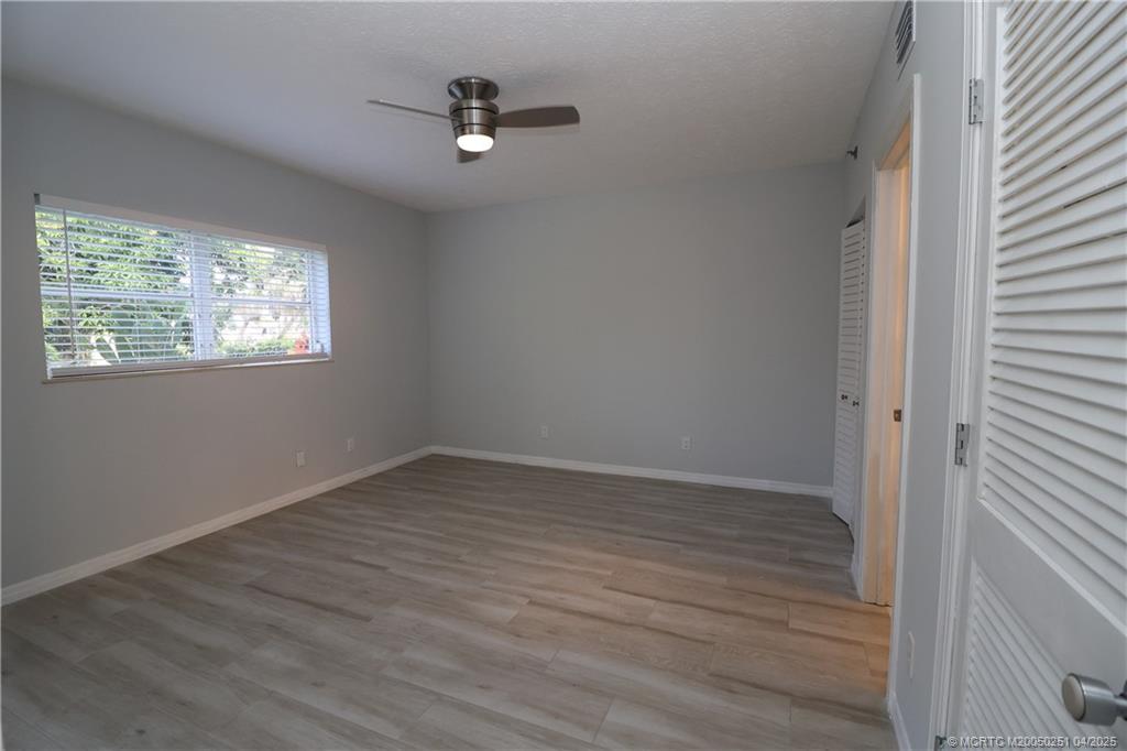 2950 Southeast Ocean Boulevard, Unit 101 Stuart, FL 34996 - Photo 13 of 35 wooden floor in an empty room with a window