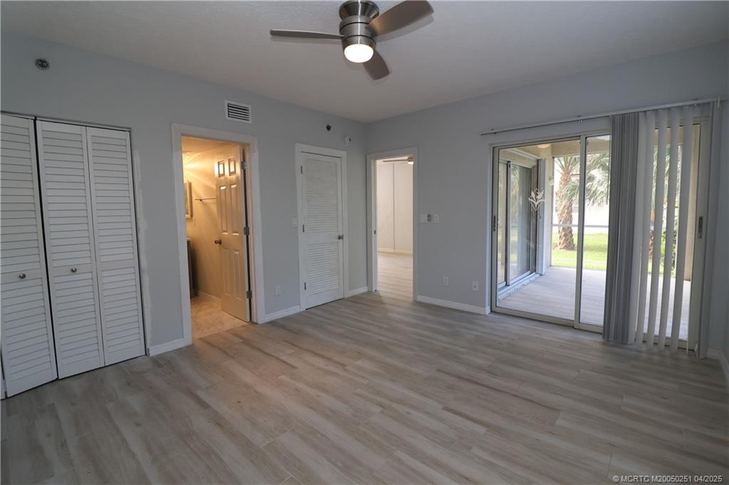 2950 Southeast Ocean Boulevard, Unit 101 Stuart, FL 34996 - Photo 14 of 35 an empty room with wooden floor cabinet and windows