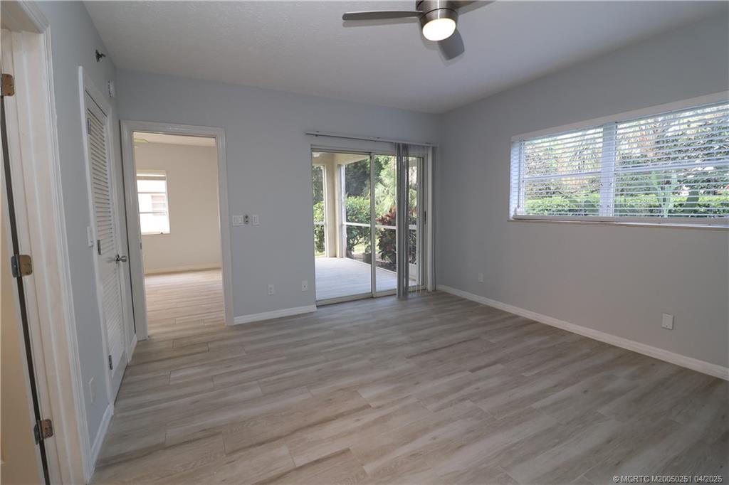 2950 Southeast Ocean Boulevard, Unit 101 Stuart, FL 34996 - Photo 16 of 35 a view of an empty room with wooden floor and a window