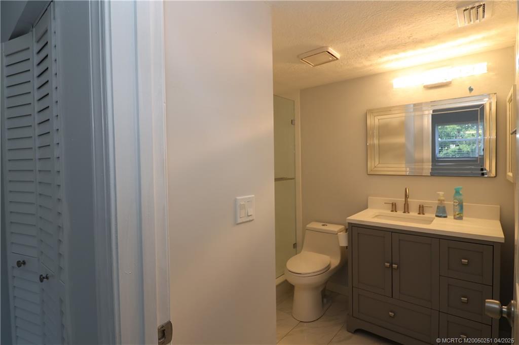 2950 Southeast Ocean Boulevard, Unit 101 Stuart, FL 34996 - Photo 17 of 35 a bathroom with a toilet a sink and mirror