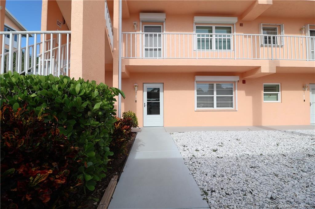 2950 Southeast Ocean Boulevard, Unit 101 Stuart, FL 34996 - Photo 2 of 35 a front view of a house with a garden