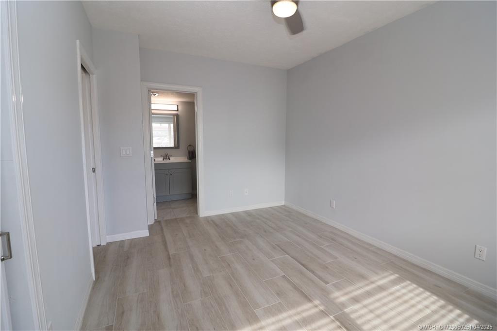 2950 Southeast Ocean Boulevard, Unit 101 Stuart, FL 34996 - Photo 24 of 35 a view of an empty room with wooden floor and a window