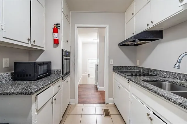 a kitchen with granite countertop a sink and a stove top oven