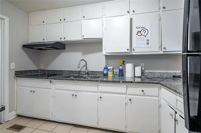 a kitchen with granite countertop white cabinets and white appliances