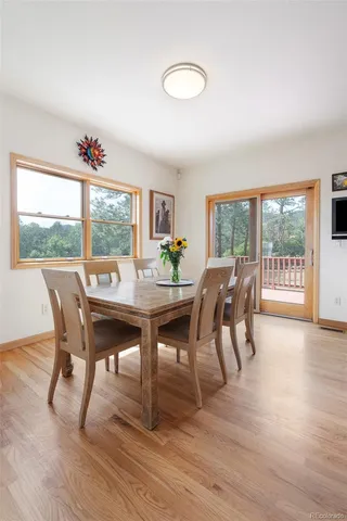 a view of a dining room with furniture wooden floor and a floor to ceiling window