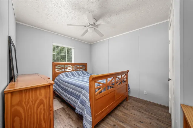a view of a bedroom with furniture and wooden floor