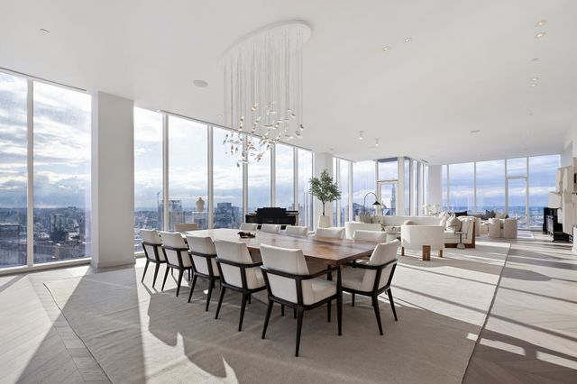 a dining room with couches a coffee table and a large window with outer view