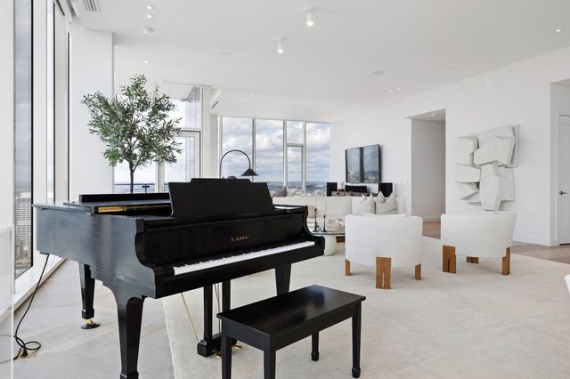 a large kitchen with kitchen island a large counter space a sink appliances and a large window