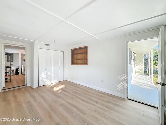 a view of an empty room with wooden floor