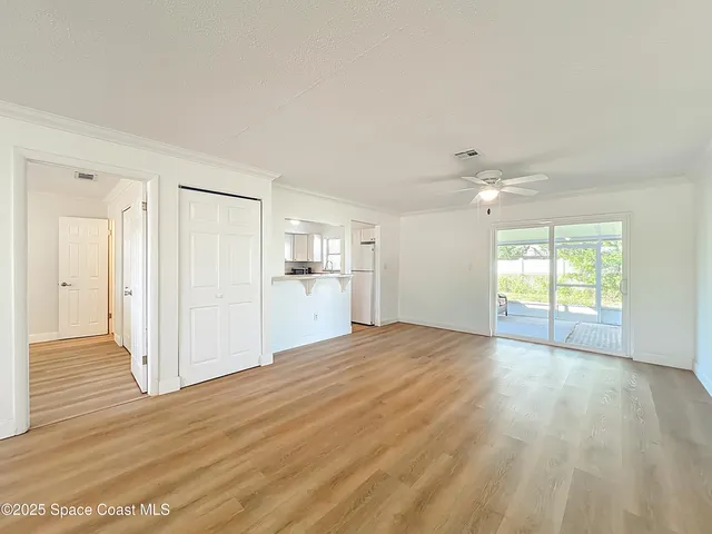 a view of empty room with wooden floor