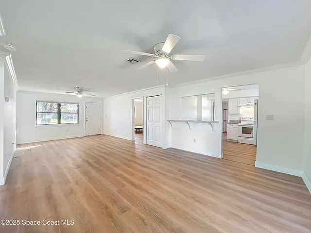 a view of empty room with wooden floor and window