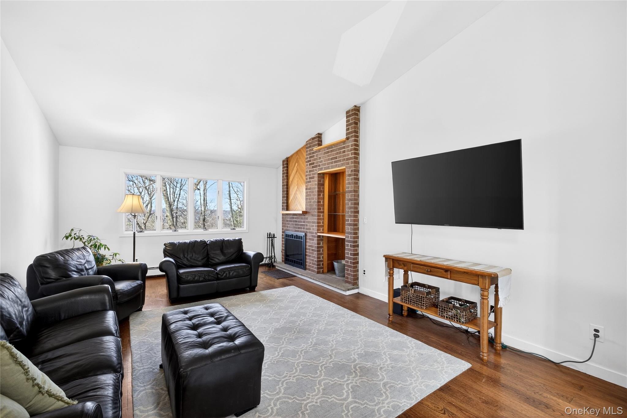 80 Ridgeview Drive Pleasantville, NY 10570 - Photo 3 of 45 A Cathedral ceiling, wood burning fireplace and a spectacular view of the sunsets make this freshly painted room a lovely gathering space.