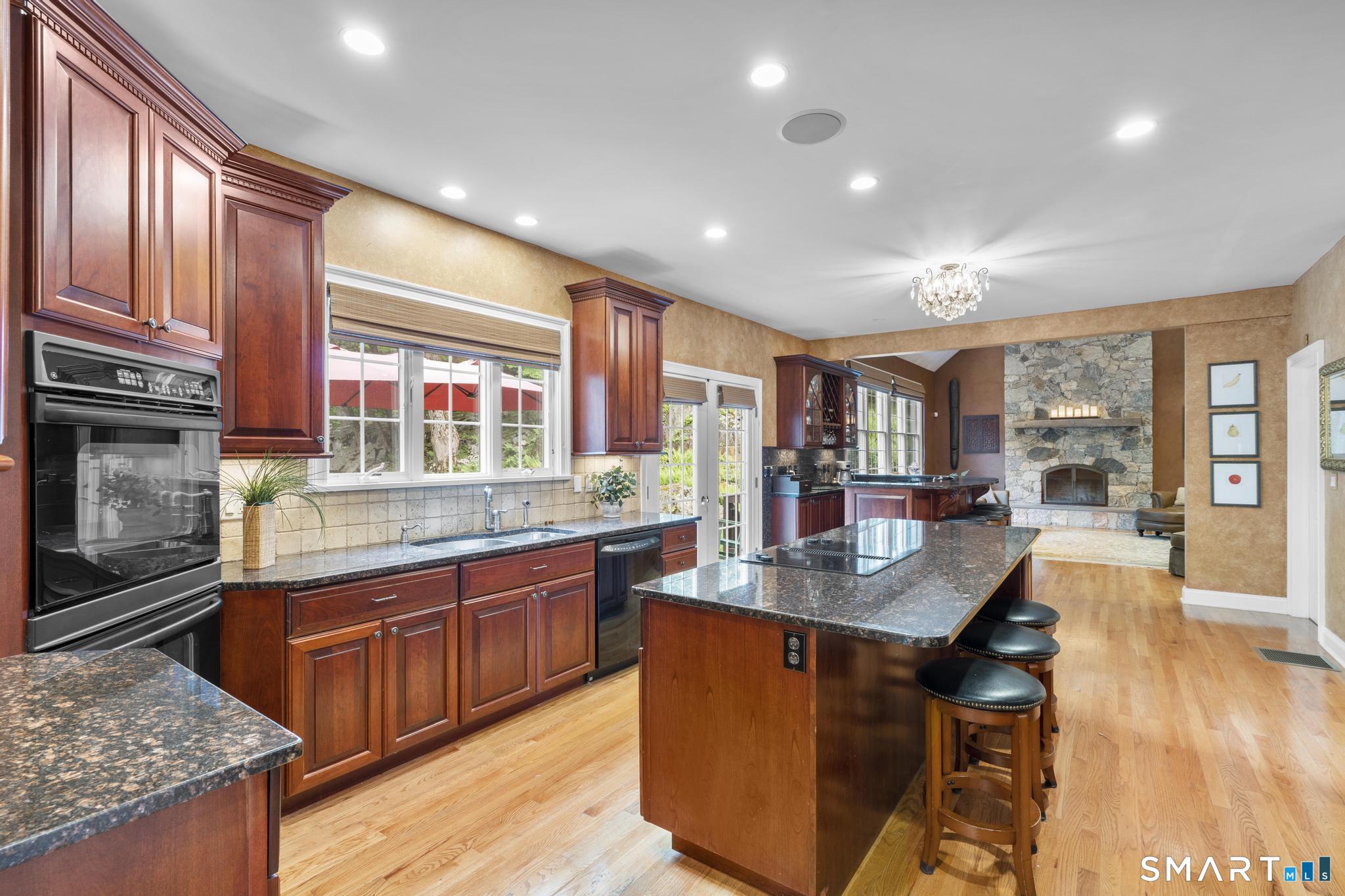 12 Logans Way Danbury, CT 06811 - Photo 2 of 40 a kitchen with stainless steel appliances granite countertop a stove top oven a sink dishwasher a dining table and chairs with wooden floor