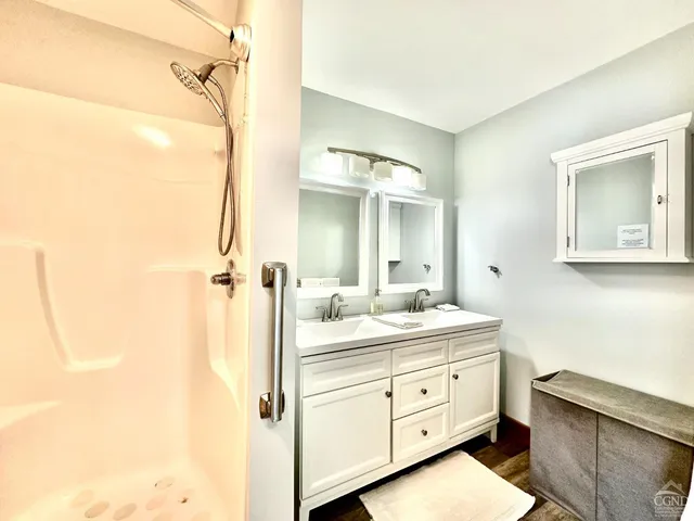 a bathroom with a double vanity sink toilet mirror and bathtub