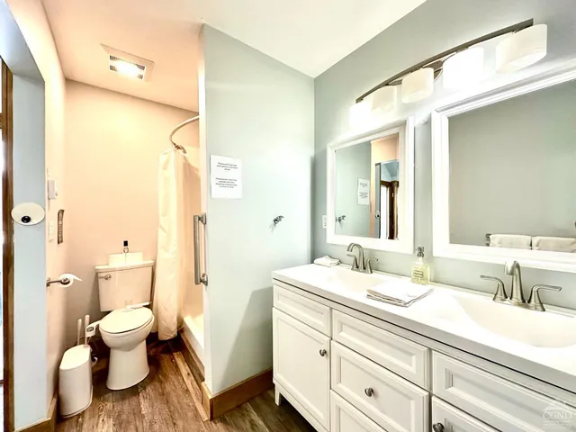 a bathroom with a double vanity sink toilet and shower