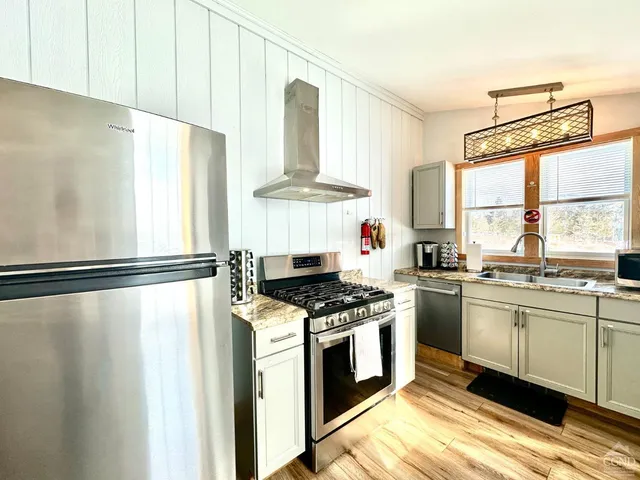 a kitchen with stainless steel appliances a stove a sink and a refrigerator