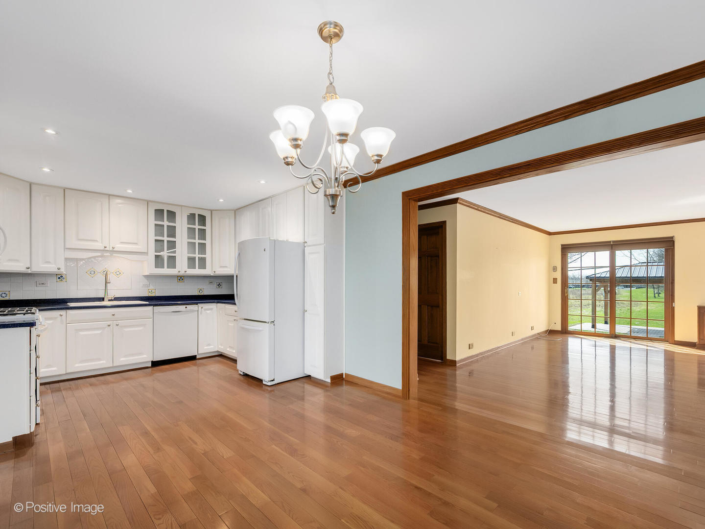 390 Arrowhead Trail Carol Stream, IL 60188 - Photo 7 of 25 a large kitchen with a refrigerator a sink dishwasher a stove and white cabinets with wooden floor