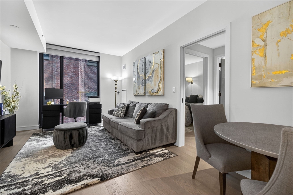 55 Lagrange Street, Unit 409 Boston, MA 02111 - Photo 1 of 29 a living room with furniture and wooden floor