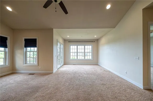 a view of a big room with windows and kitchen view