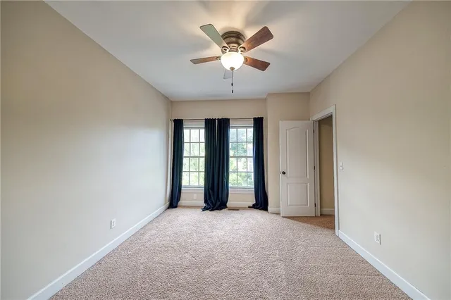 an empty room with closet and a chandelier fan