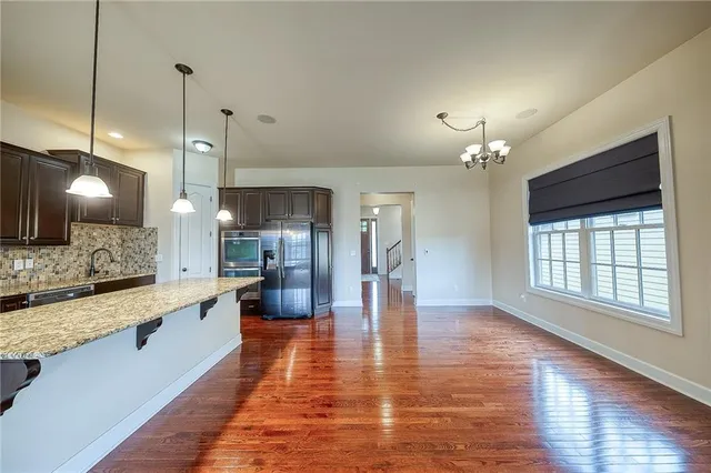 a large kitchen with a wooden floor and stainless steel appliances