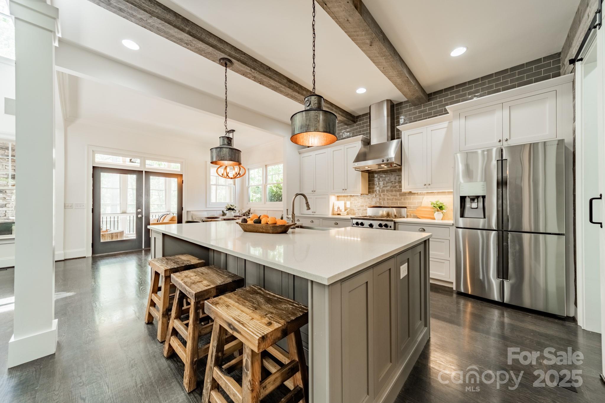 5868 Savona Terrace Fort Mill, SC 29708 - Photo 18 of 46 a kitchen with stainless steel appliances a sink a stove a refrigerator and island with wooden floor