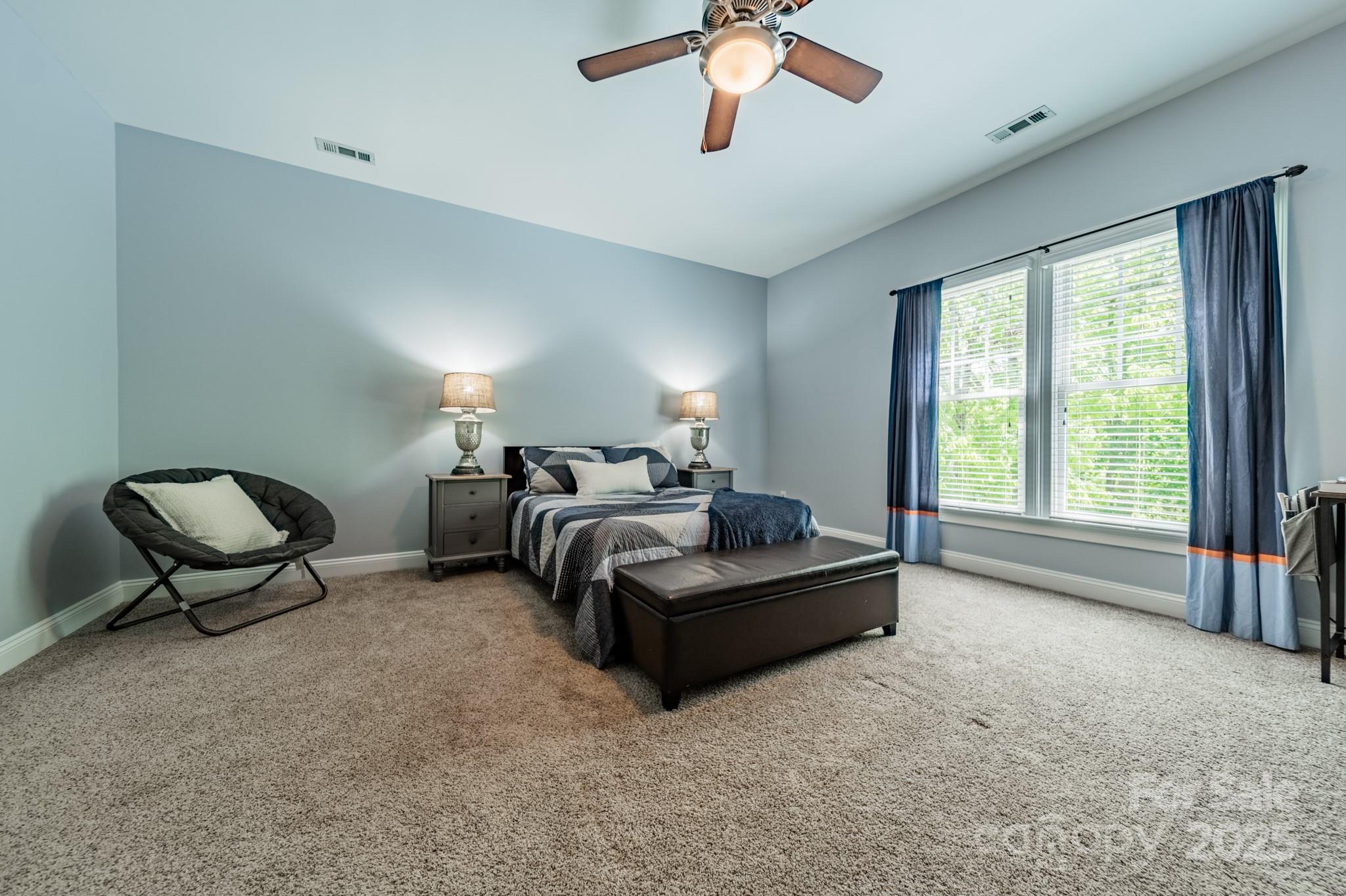 5868 Savona Terrace Fort Mill, SC 29708 - Photo 29 of 46 a spacious bedroom with a bed and a chandelier